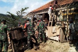 Babinsa Situgede bahumembahu bersama warga saat membersihkan puing reruntuhan rumah warga.